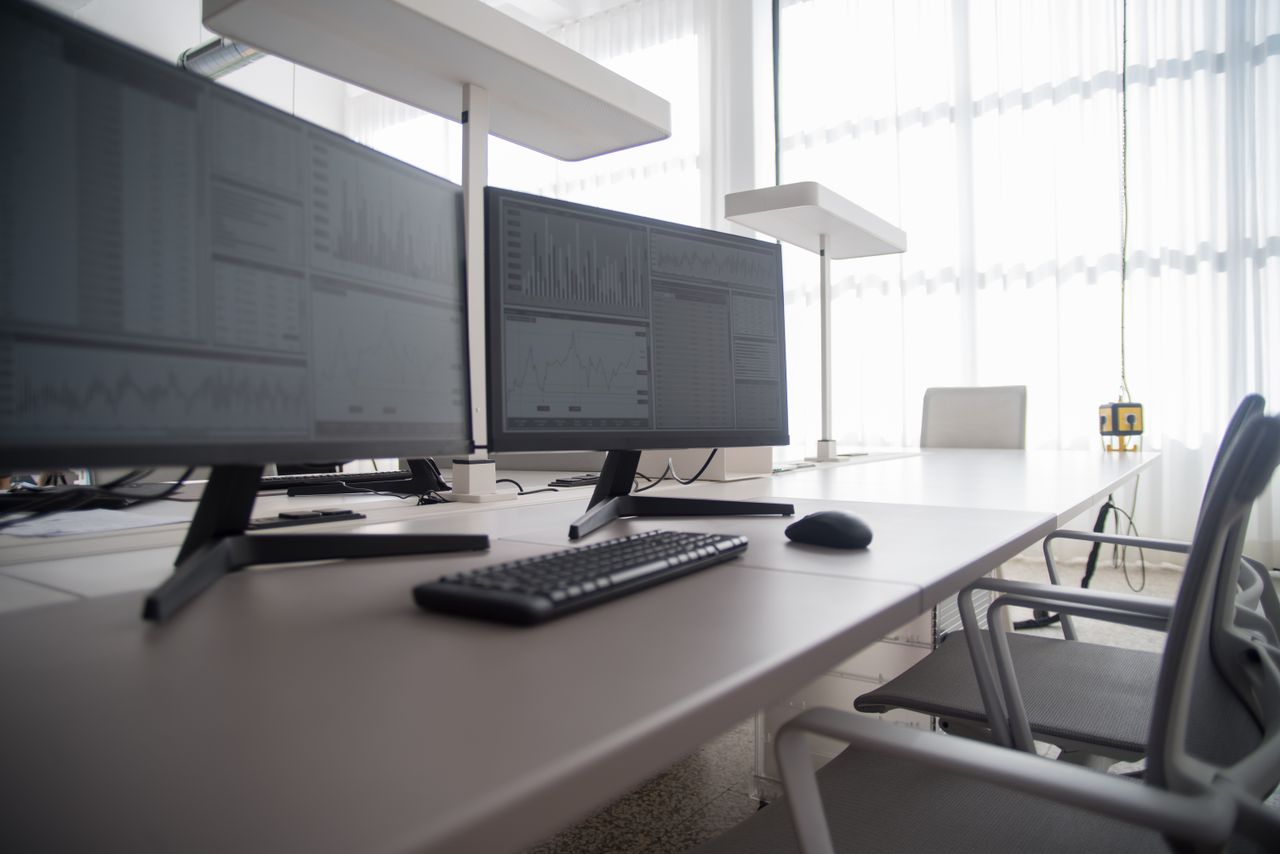Stylish contemporary office featuring multiple computer monitors and ergonomic chairs.